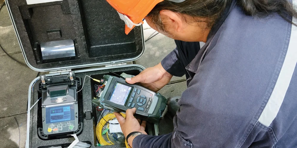 technician using OTDR to test fiber optic splices